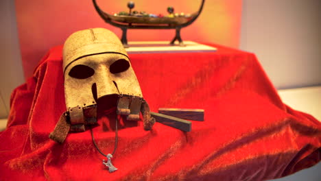 Artefacto-De-Máscara-Vikinga-En-Tela-Roja