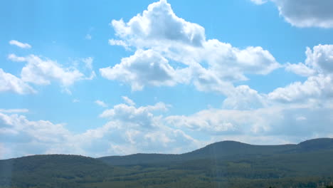 Sich-Bewegende-Wolken-Im-Zeitraffer-Und-Blauer-Himmel-Und-Grüne-Hügel