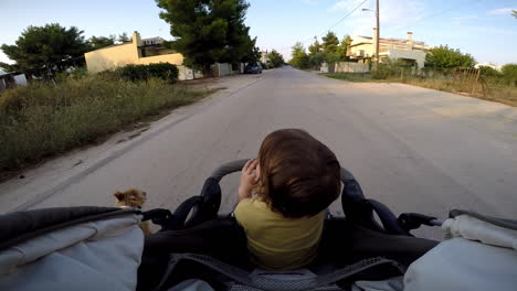 POV-footage-of-a-boy-in-a-stroller-taking-a-ride-at-Kifissia-city,-Greece-Wide-shot