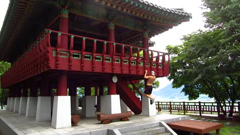 Young-muscular-male-exercising-at-Korean-pagoda