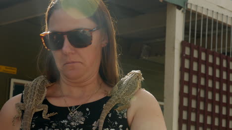 Woman-holds-onto-two-Australian-bearded-dragon-lizards