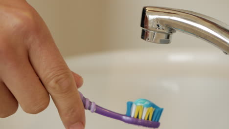 Mann-Trägt-Zahnpasta-Auf-Eine-Zahnbürste-Auf