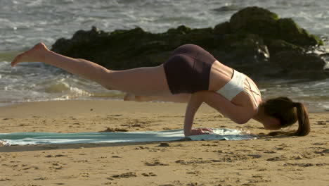 Eine-Attraktive-Junge-Frau,-Die-Yoga-An-Einem-Wunderschönen-Strand-In-Kalifornien-Praktiziert