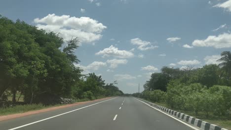 a-beautiful-view-of-empty-highway-with-trees-and-bushes-on-both-side-of-the-roads-and-a-beautiful-sky-over-head