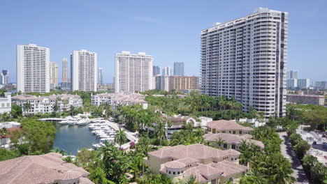 Aerial-Shot-Flying-Backwards-of-Aventura-Florida-Marina,-Revealing-Beautiful-Luxury-Condos-and-Homes