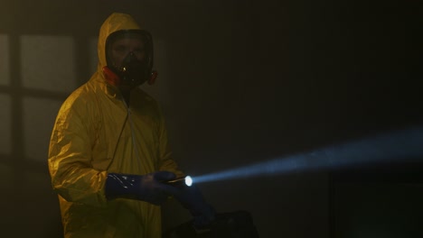 Hazmat-suit-wearing-man-explores-a-smoky-room