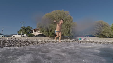 Aufnahmen-Eines-Zweijährigen-Jungen,-Der-Am-Strand-Von-Santova,-Kalamata,-Griechenland,-Mit-Wellen-Spielt
