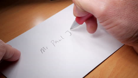 Man-writes-an-address-on-a-white-envelope