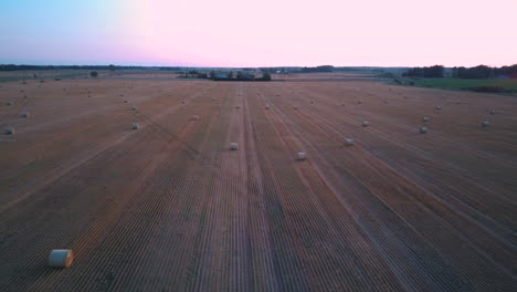Flying-Above-the-Field-With-Hay-Rolls-Sunrise