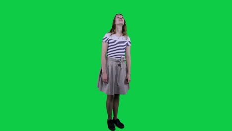 Side-view-teenage-girl-vibing-to-music-in-front-of-a-green-screen
