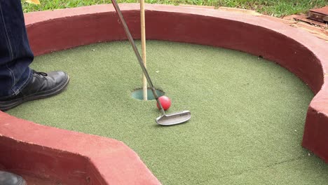 Player-Potting-the-Ball-on-the-Green-of-the-Mini-Golf-Course