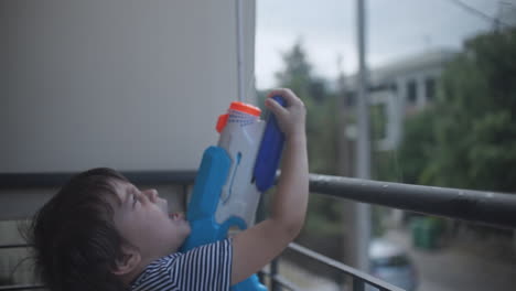Footage-of-a-little-caucasian-boy-playing-with-a-water-gun-toy