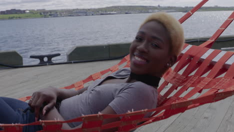 A-beautiful,-young-woman-lying-in-a-hammock-along-the-Halifax-waterfront