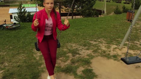 Girl-with-red-jacket-swinging-on-the-swing-set