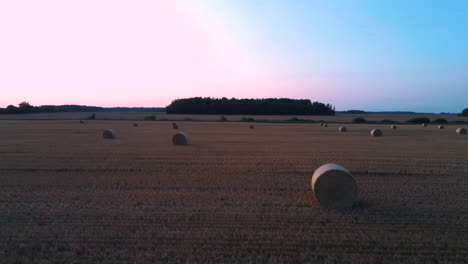 Flying-Above-the-Field-With-Hay-Rolls-Sunrise