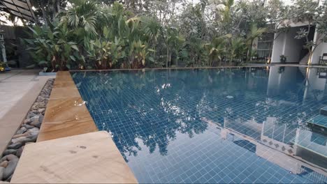 Slider-Shot-of-a-Crystal-Clear-Swimming-Pool-in-the-Grounds-of-a-Tropical-Hotel