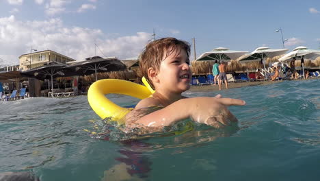 Footage-of-Caucasian-boy-having-fun-with-waves-at-Kalamata-beach,-Greece