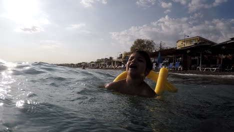 Aufnahmen-Eines-Kaukasischen-Jungen,-Der-Sich-Mit-Wellen-Am-Strand-Von-Kalamata,-Griechenland,-Amüsiert