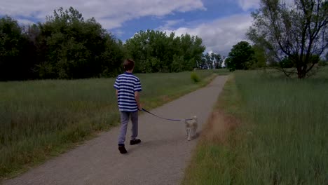 Teen-boy-walking-cute-dog-on-a-nature-trail