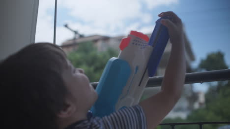 Aufnahmen-Eines-Kleinen-Kaukasischen-Jungen,-Der-Mit-Einem-Wasserpistolenspielzeug-Spielt