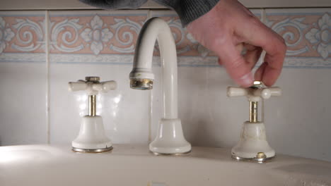 Handyman-puts-tap-handle-and-nut-back-on-faucet