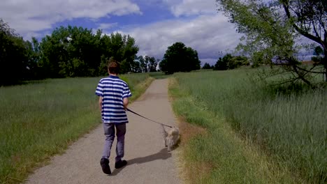 Teen-boy-walking-cute-dog-on-a-nature-trail
