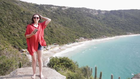 Young-girl-taking-selfie-on-the-top-of-Praia-Brava-mountain-in-Arraial-do-Cabo,-Rio-de-Janeiro