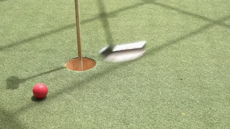 Golfer-Takes-a-Few-Shots-to-Get-the-Golf-Ball-in-the-Hole-at-the-Mini-Golf