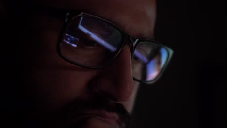 Asiatischer-Mann-Mit-Reflexion-Von-Computerbildschirmen,-Die-In-Einer-Brille-In-Einem-Dunklen-Raum-Zu-Sehen-Sind