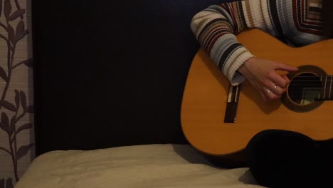 Schwenk-Eines-Mädchens,-Das-Gitarre-Auf-Dem-Bett-übt