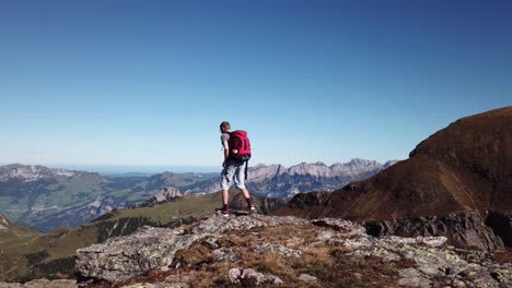 Adult-Male-Hiker-With-Backpack-Reaching-Mountain-Viewpoint-In-Switzerland