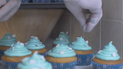 Woman-decorating-cupcakes,-wearing-white-latex-gloves-120fps