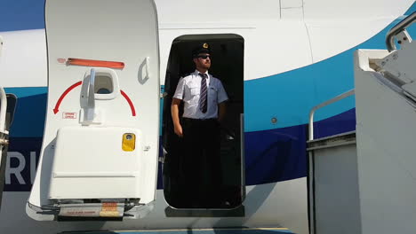 Steward-stands-on-treshold-of-airplane-door