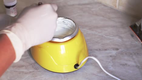 Caucasian-woman-using-an-electric-candy-melting-pot