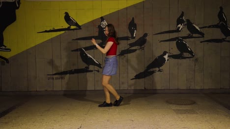 Teenage-girl-dancing-in-front-of-graffiti-art-at-night
