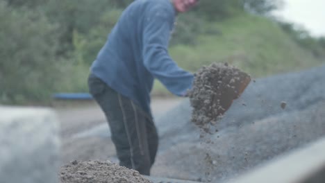 Hard-working-man-shovelling-sand-onto-pickup-bed