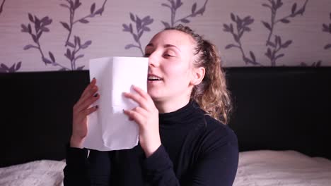 Teenage-girl-sneezing-into-a-tissue