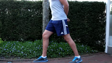 Low-angle-of-Sporty-Man-Stretching-Legs-Before-Fitness-Training-Outdoor