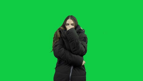 Girl-freezing-with-warm-jacket-in-front-of-a-green-screen