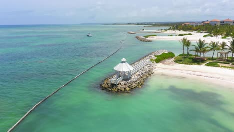 Panoramic-view-of-the-kiosk-at-the-entrance-to-the-marina-of-Cap-Cana-with-catamaran-in-the-sea,-blue-waters-and-fresh-air