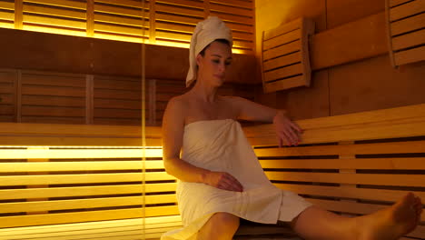 Beautiful-adult-woman-walking-into-a-modern-Finnish-sauna