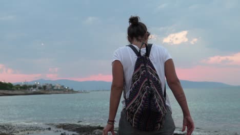 Slow-motion-of-caucasian-woman-walking-on-a-beach-at-Agkistri-island,-Argosaronikos,-Greece