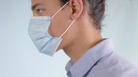 Man-Putting-on-Disposable-Surgical-Face-Mask,-Extreme-Closeup-Profile