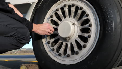 Man-Checks-Tyre-Pressure-Of-Aircraft-Wheel-Close-Up