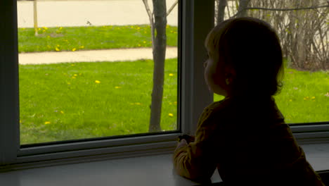 Toddler-boy-looking-out-a-window