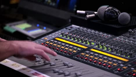 Sound-Tech-uses-a-Pro-Audio-Mixer-Console,-Fixed-Close-Up-of-Male-Hands