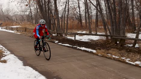 Racing-cyclist-rides-past-on-a-cold-snowy-day
