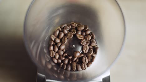Draufsicht-Auf-Aromatische-Kaffeebohnen,-Die-Durch-Keramikgrate-Mahlen-Und-Zerkleinern-Und-Im-Kaffeekorb-Wirbeln