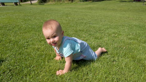 Baby-boy-crawling-through-the-grass-on-a-warm,-summer-day