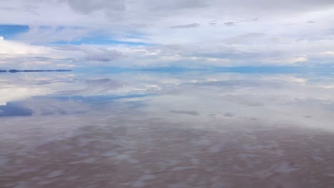Sideways-view-of-endless-horizon-and-mirror-effect-of-cloudy-sky-on-salt-lake